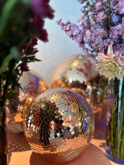 Three disco balls among purple flowers as event decoration at event venue Frankfurt GOOSE Eventspace