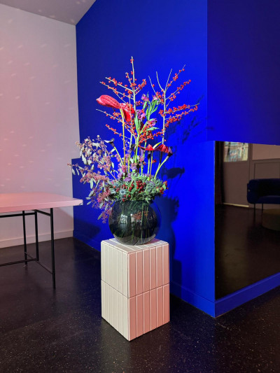 Große Blumendekoration vor blauer Wand