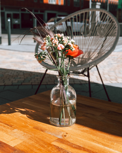 Floral arrangement on a wooden table at summer party venue Frankfurt GOOSE Eventspace