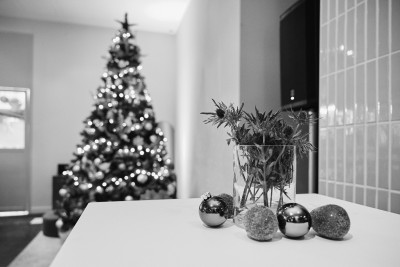 Weihnachtliche Tischdekoration, im Hintergrund ein geschmückter Weihnachtsbaum